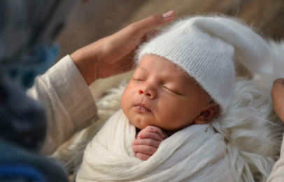 Newborn sleeping baby on mother's lap