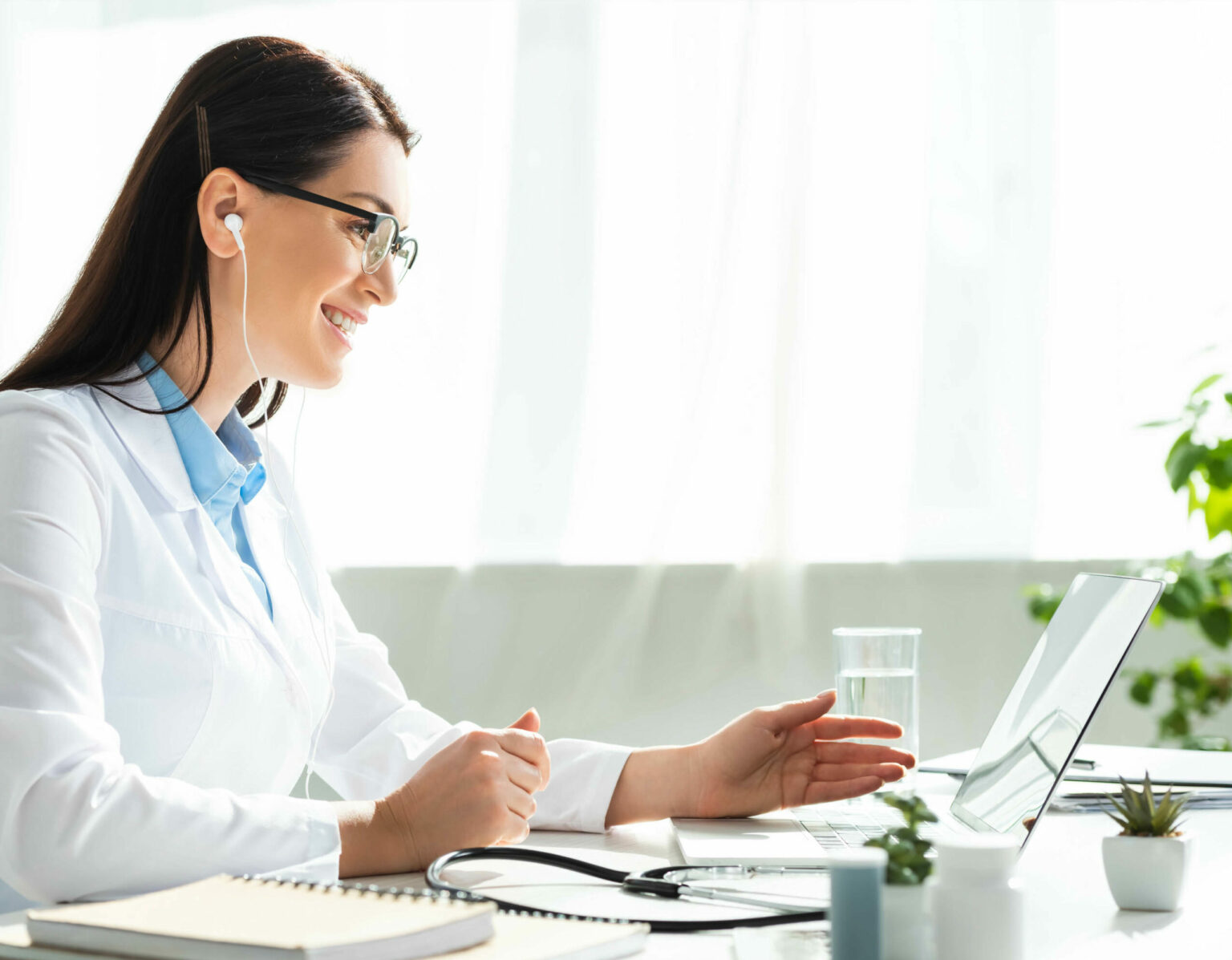 Practitioner working from her office on laptop video chatting with clients